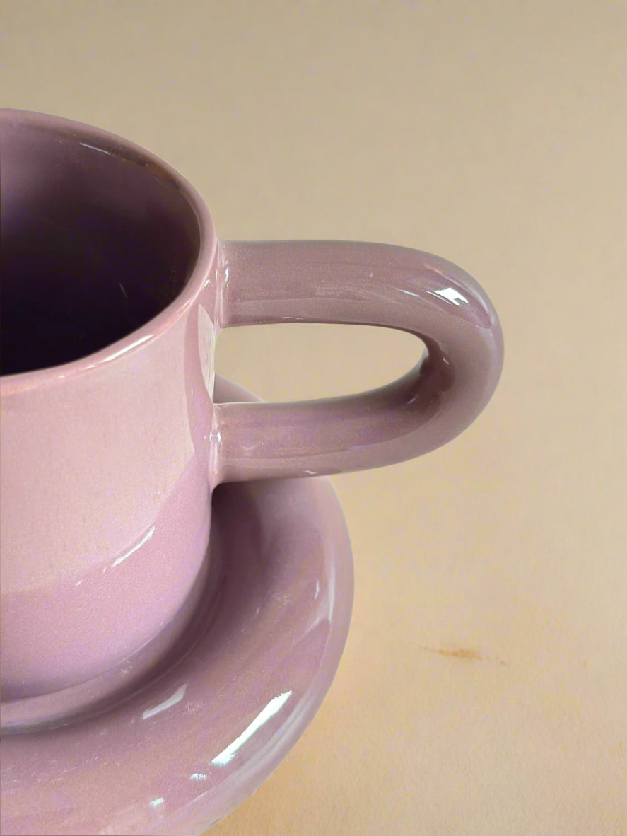 a pink coffee cup sitting on top of a saucer