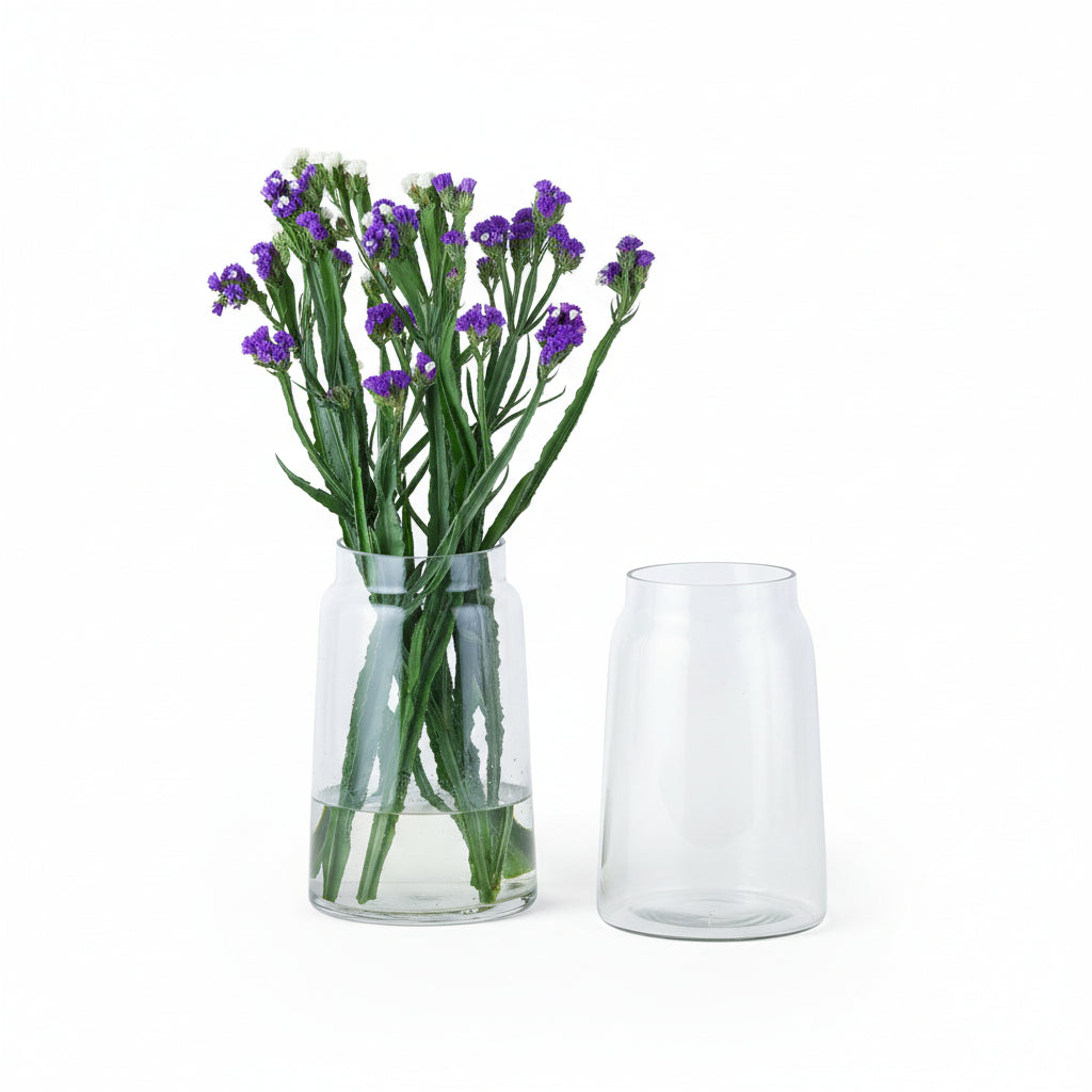 a vase with purple flowers sitting next to a book