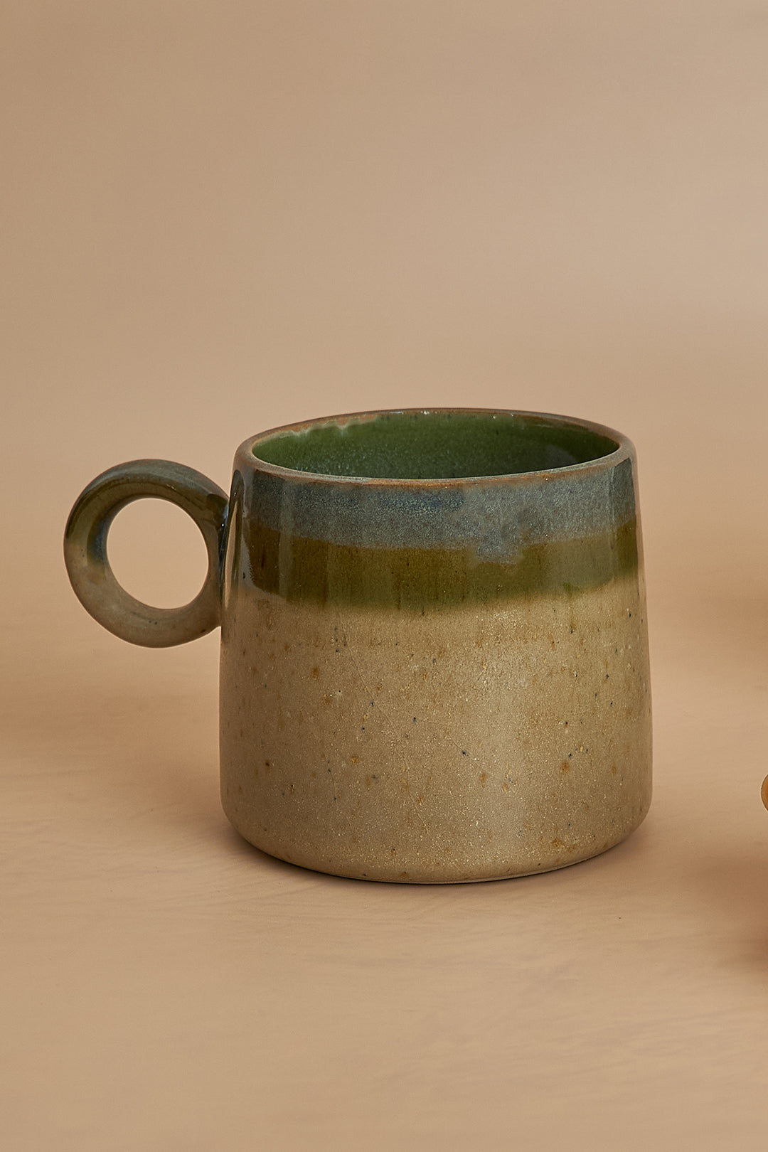 a coffee cup sitting next to a cookie on a table
