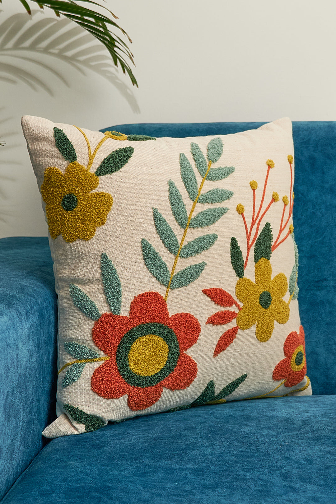 a blue couch with a flowered pillow on it