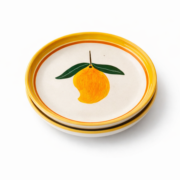 Stack of ceramic plates with lemon design on a white background