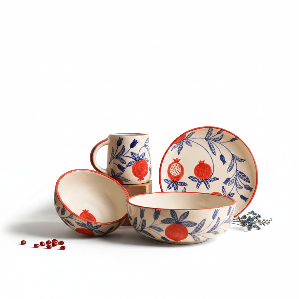 Ceramic tableware set with pomegranate design on a white background