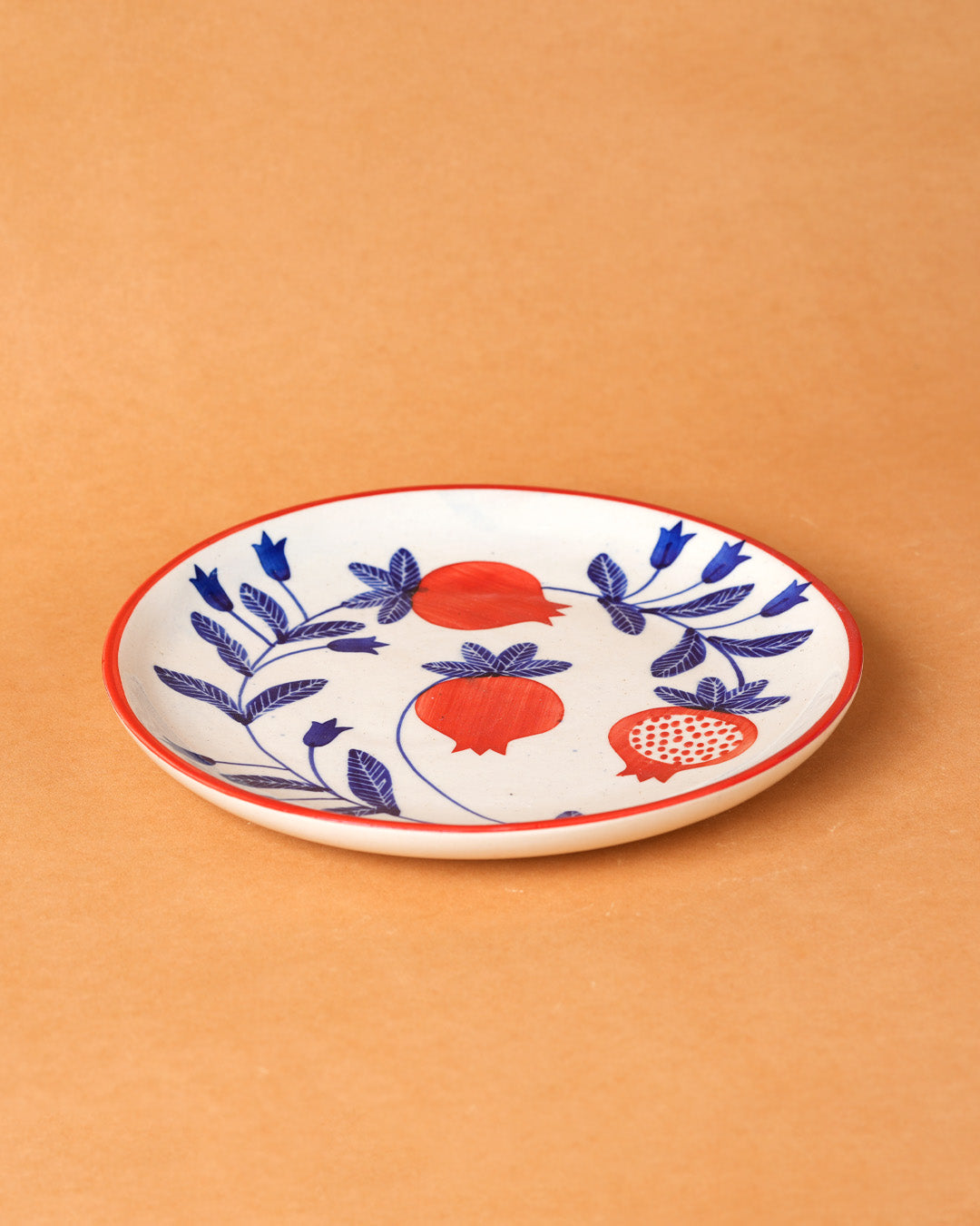 Decorative plate with red and blue floral patterns on a beige background