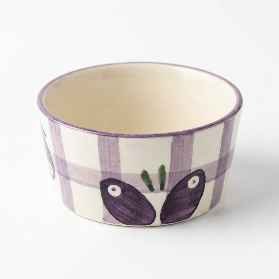Ceramic bowl with purple checkered pattern and leaf design on a white background