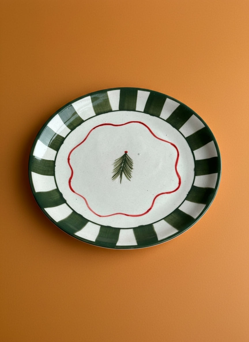 Decorative plate with green and white stripes and a red border on an orange background