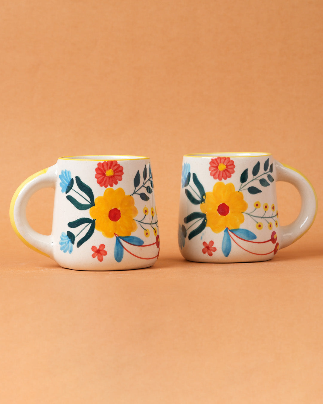 Two floral mugs on a beige background