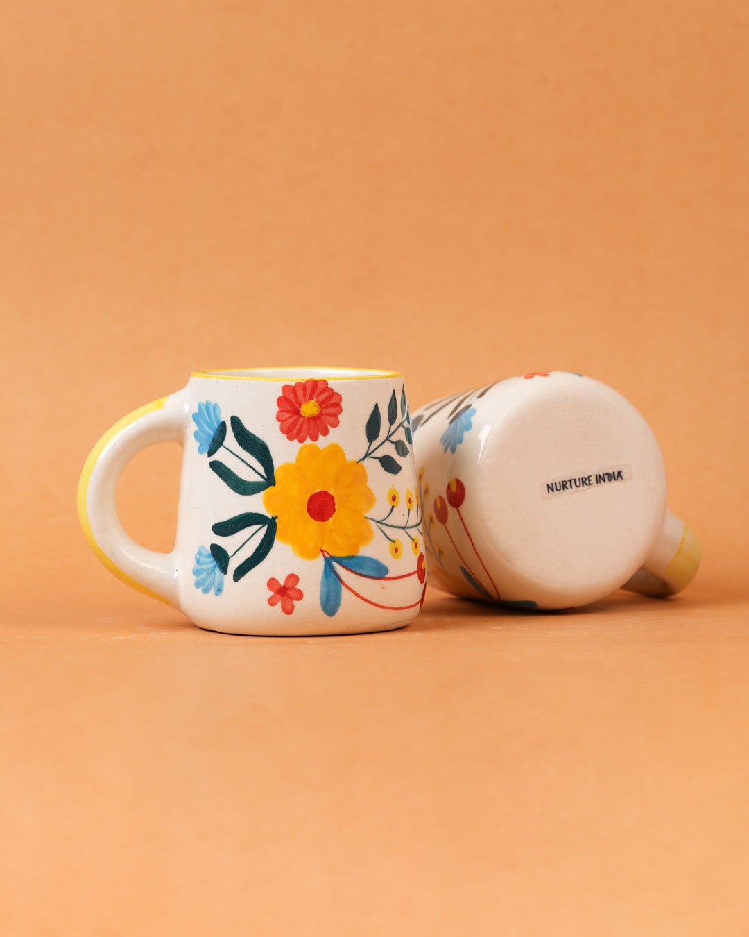 Decorative mug with floral design on an orange background