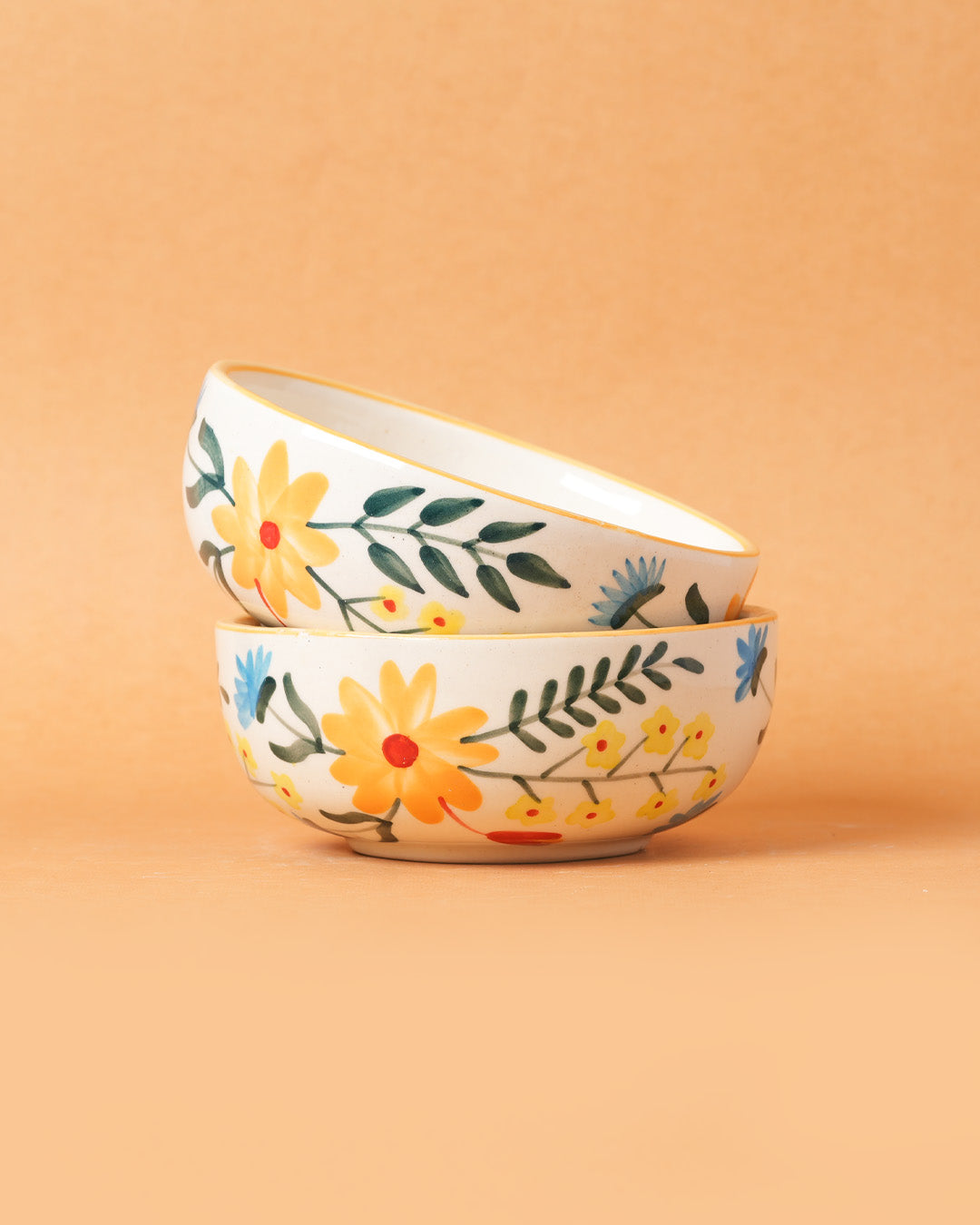 Two stacked ceramic bowls with floral designs on a beige background