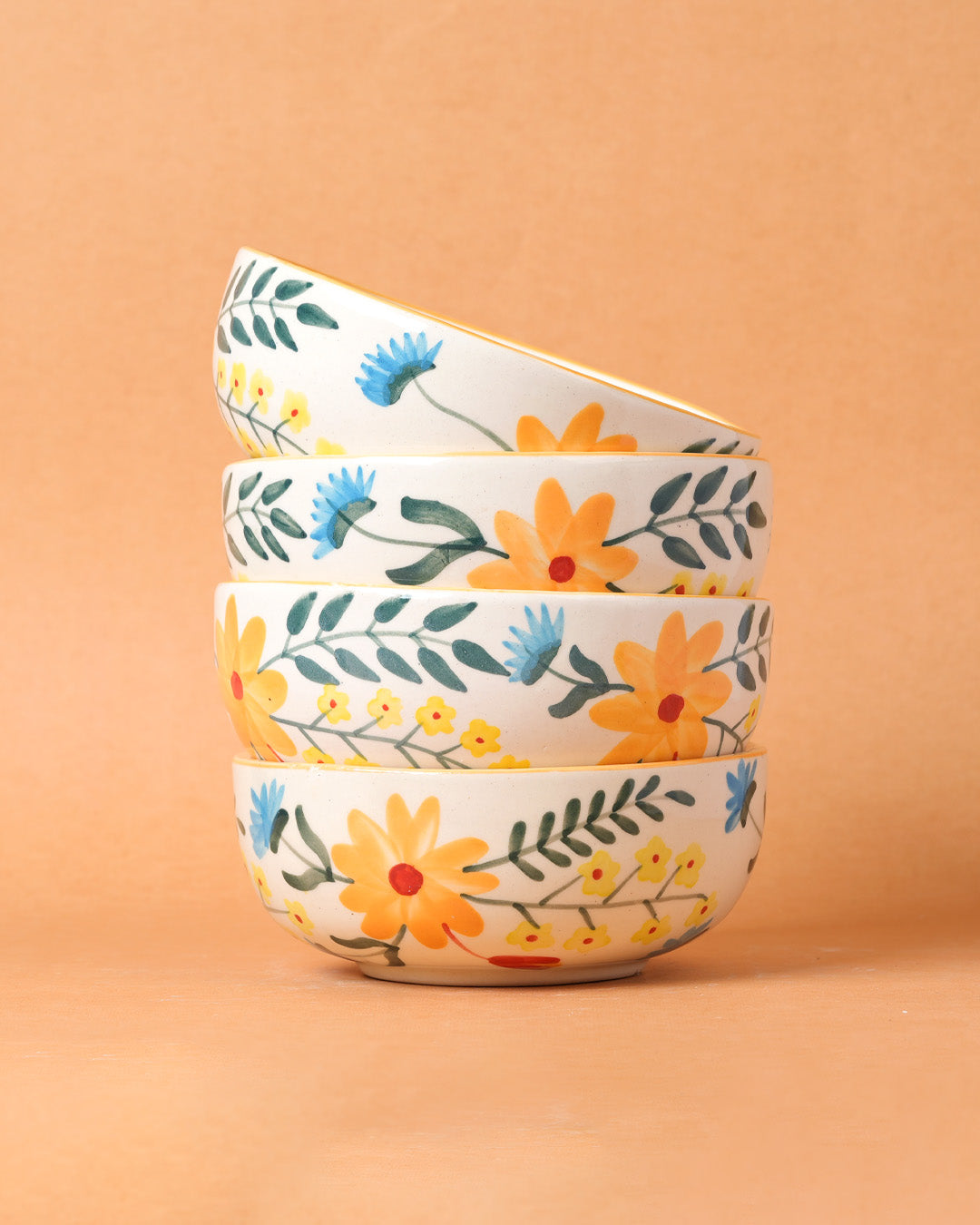 Set of three floral-patterned bowls stacked on a peach background