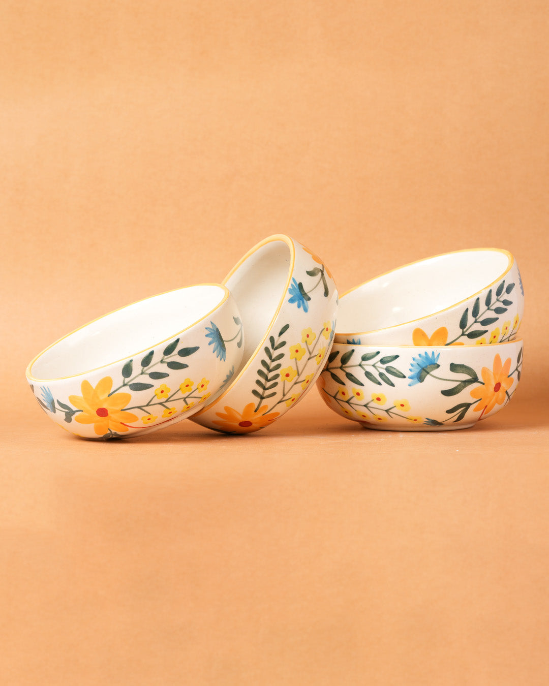 Three ceramic bowls with floral designs on a beige background