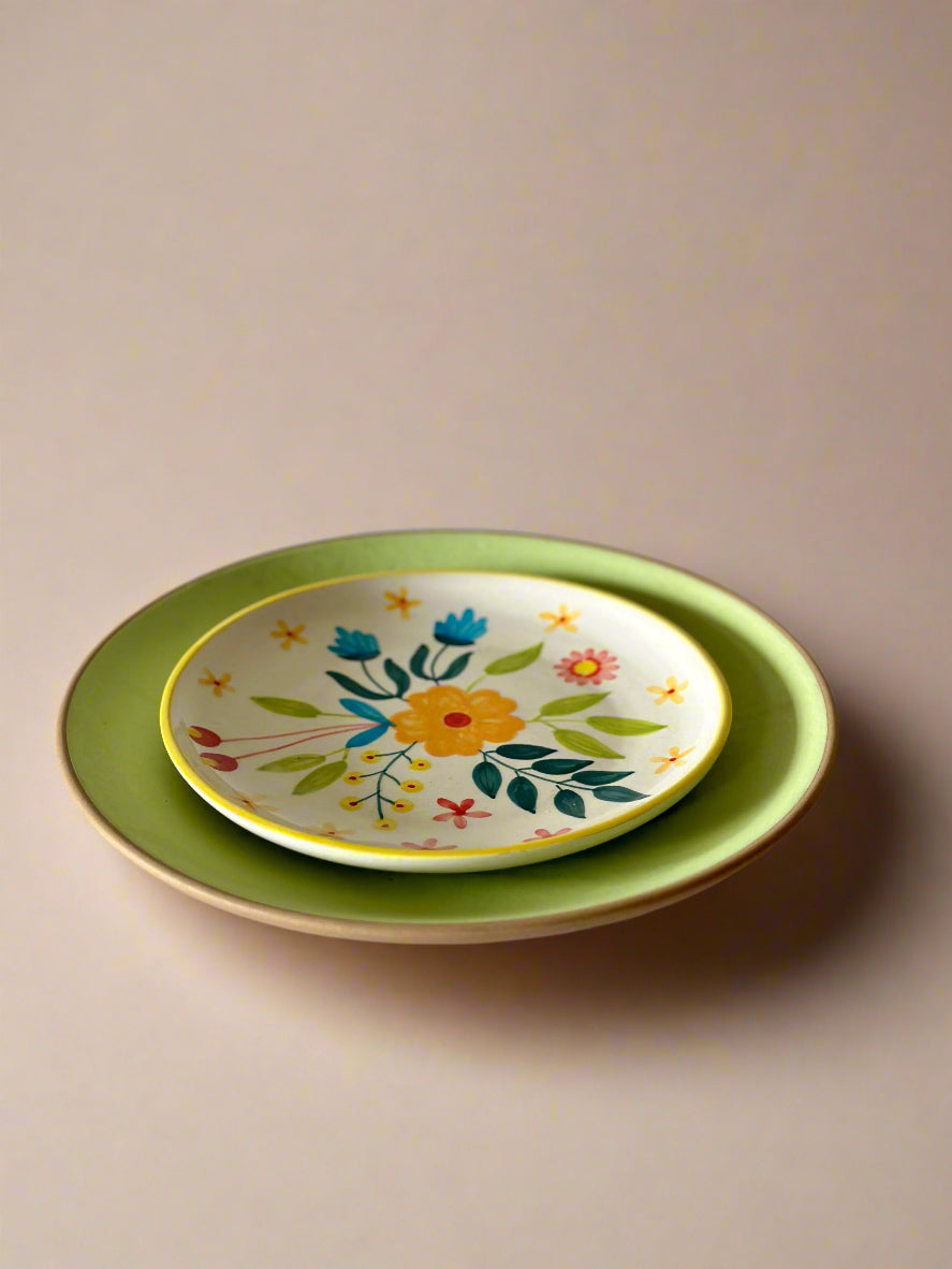 Two ceramic plates, one with floral design on a plain background