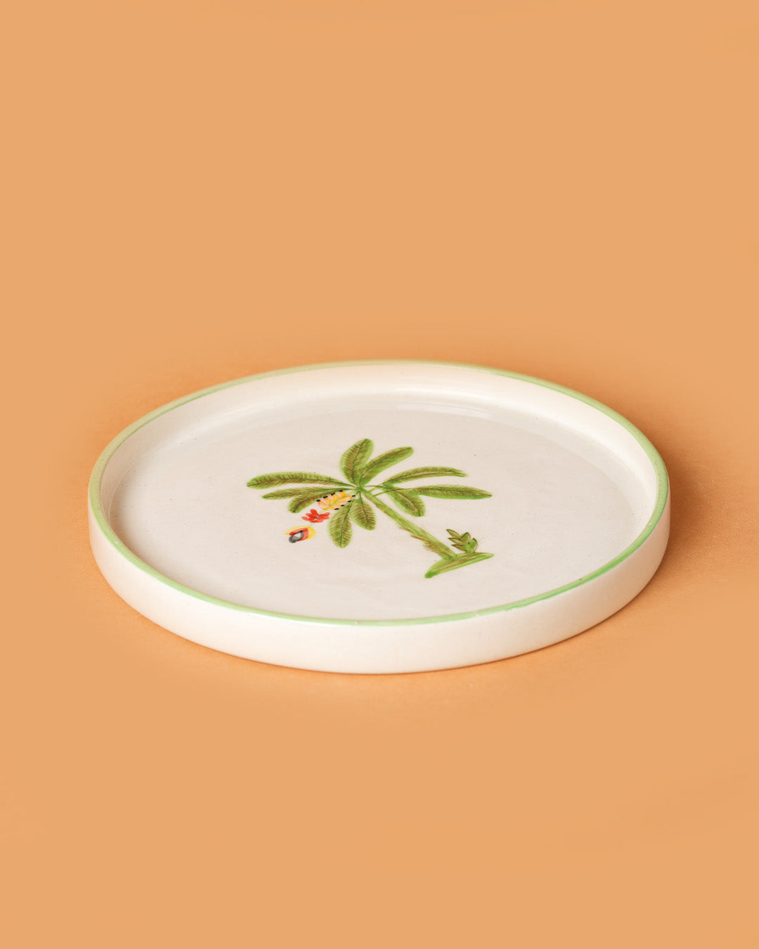 White ceramic plate with a palm tree design on a beige background