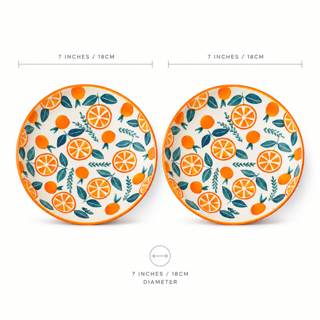 Two ceramic plates with orange and leaf pattern on a white background