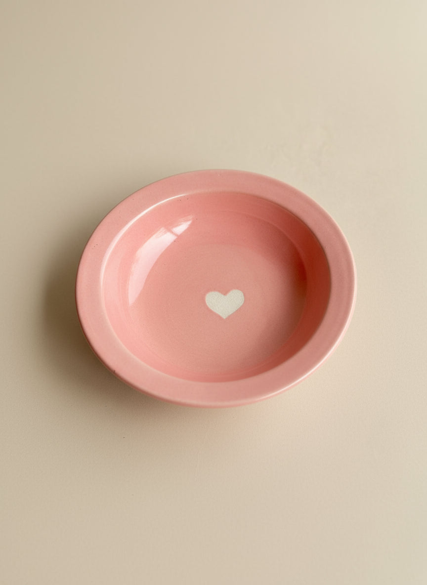 Pink bowl with a white heart on a beige background