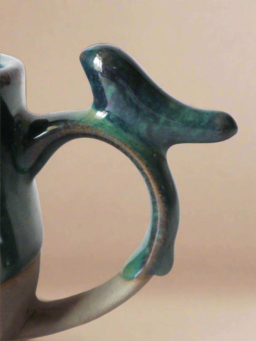 a close up of a ceramic cup with a handle