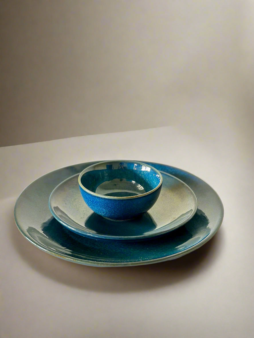 Set of blue ceramic plates on a white surface