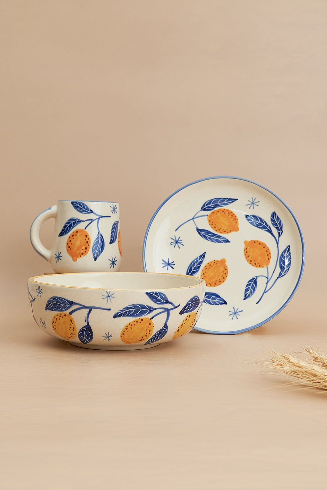 A set of breakfastware with a floral pattern, predominantly featuring yellow and green colors, on a beige background.