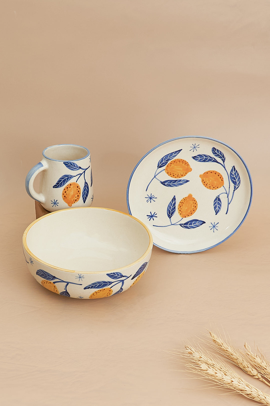 A set of breakfastware with a floral pattern, predominantly featuring yellow and green colors, on a beige background.