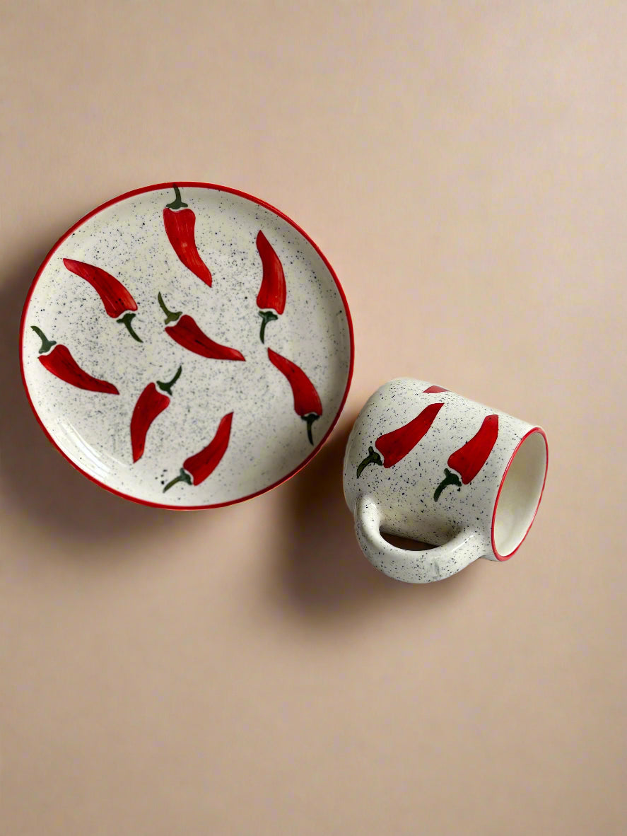 Ceramic plate and mug with red chili pepper design on a white background