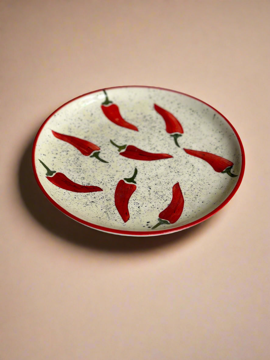 Ceramic plate with red chili pepper design on a plain background