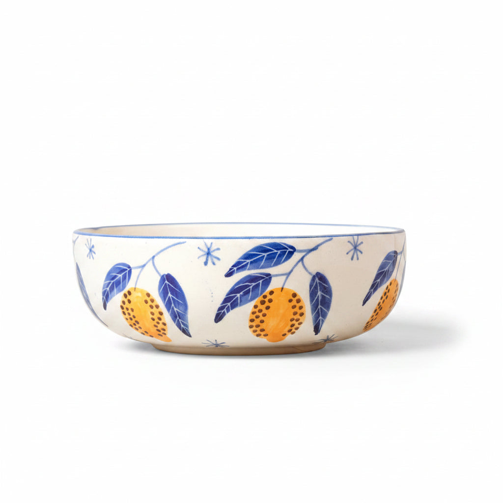 Ceramic bowl with leaf and fruit design on a beige background