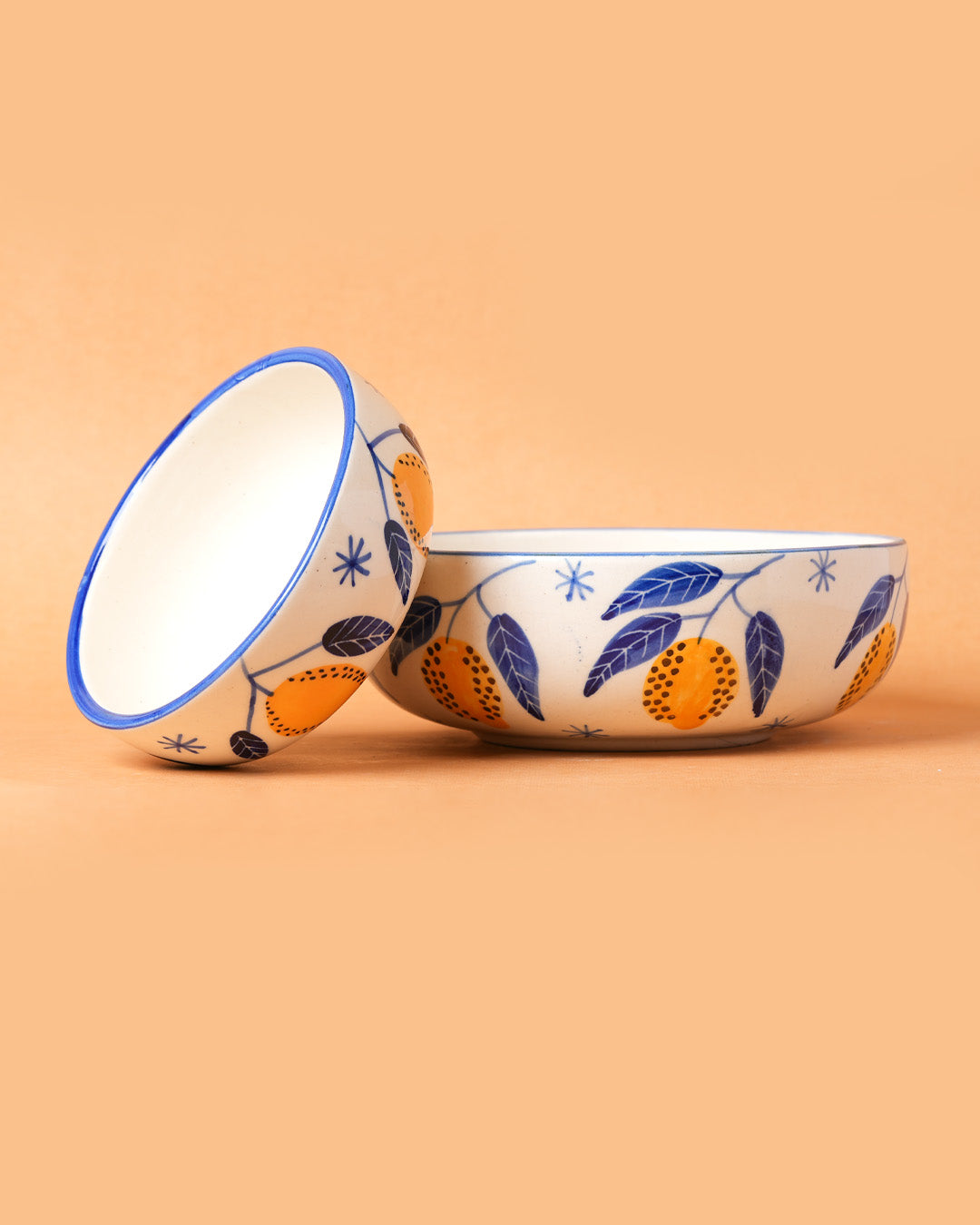 Decorative ceramic bowl with floral and fruit design on a beige background