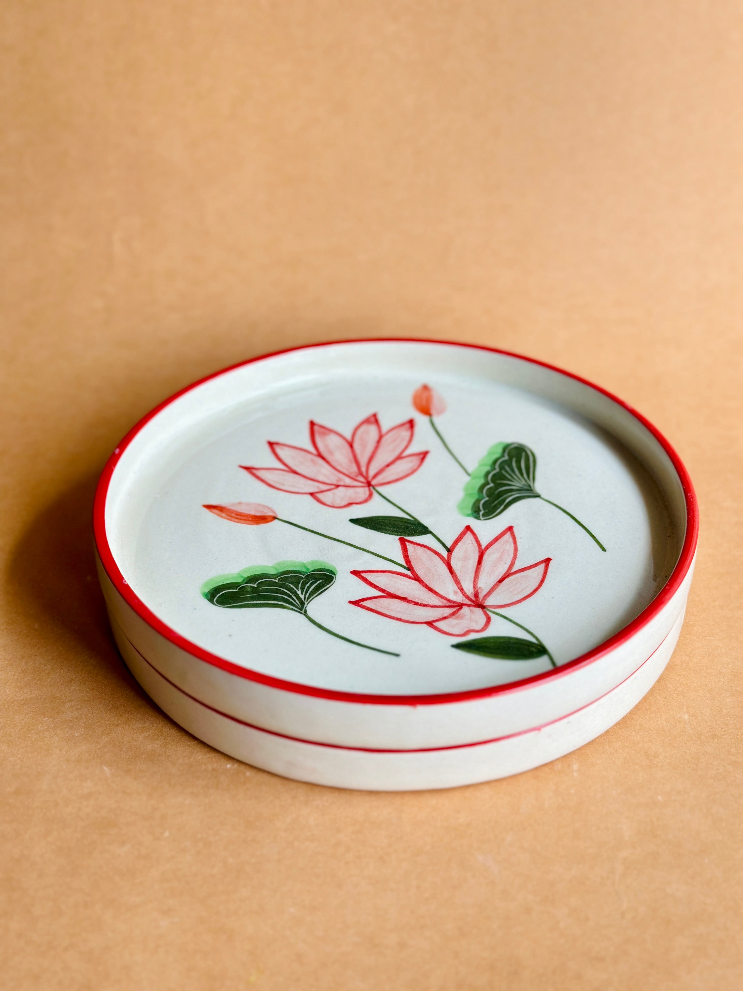 Ceramic dish with lotus flower design on a beige background