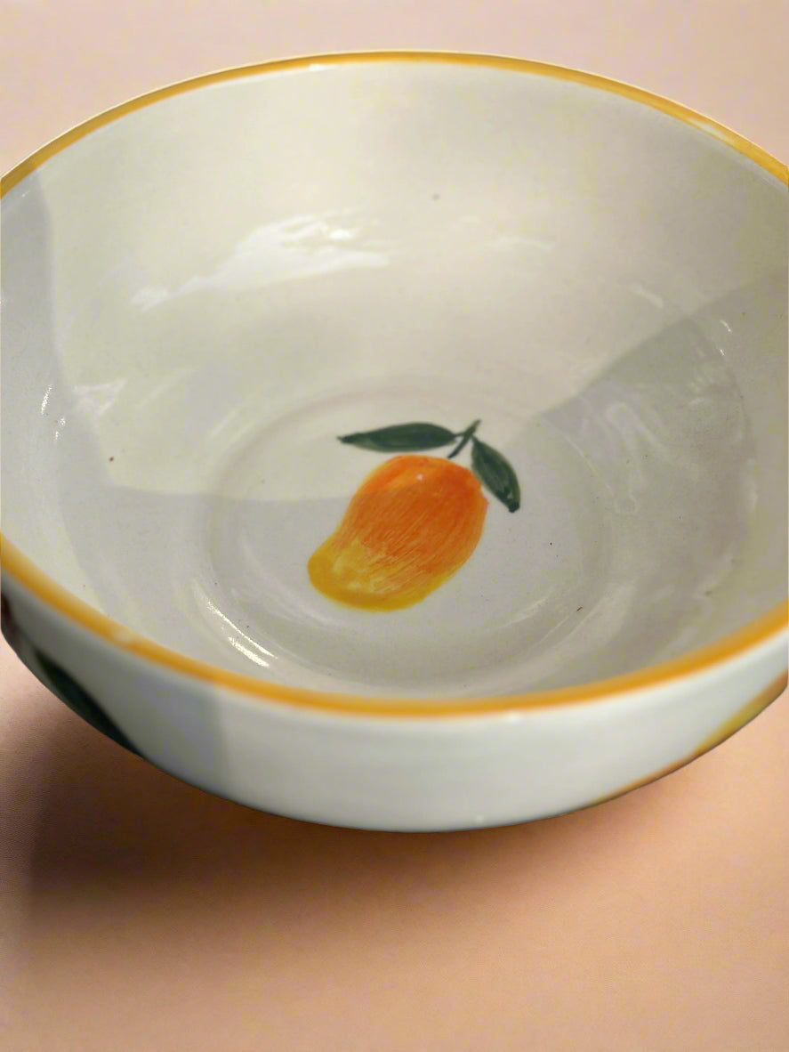 White bowl with a gold rim and an orange design on a pink background