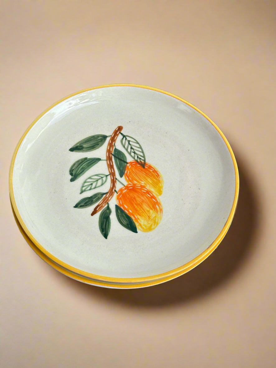 Ceramic plate with a decorative design of peaches on a black textured surface