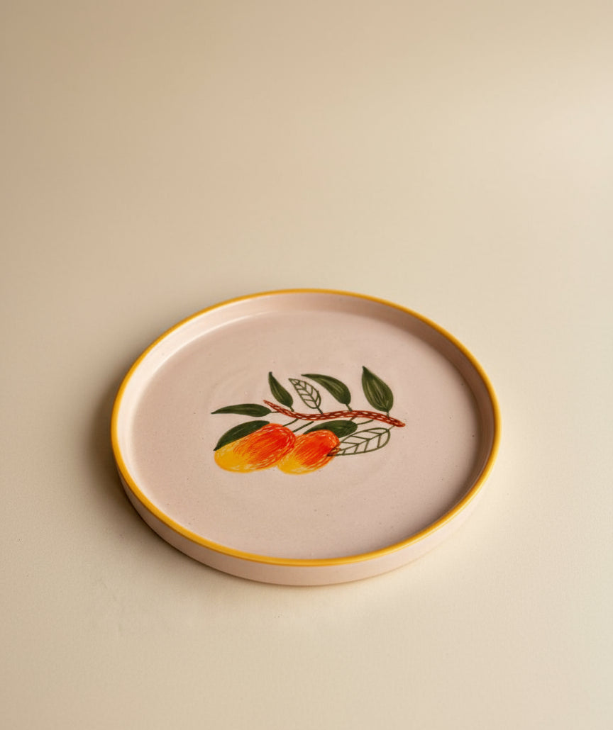 Round ceramic plate with a decorative design of fruits on a beige background