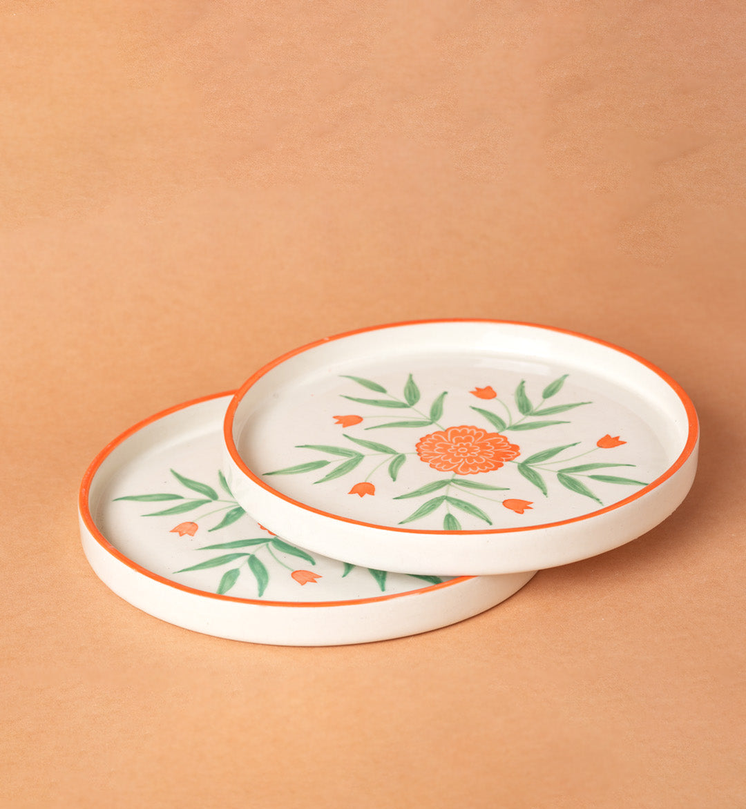 Two ceramic plates with floral designs on a beige background