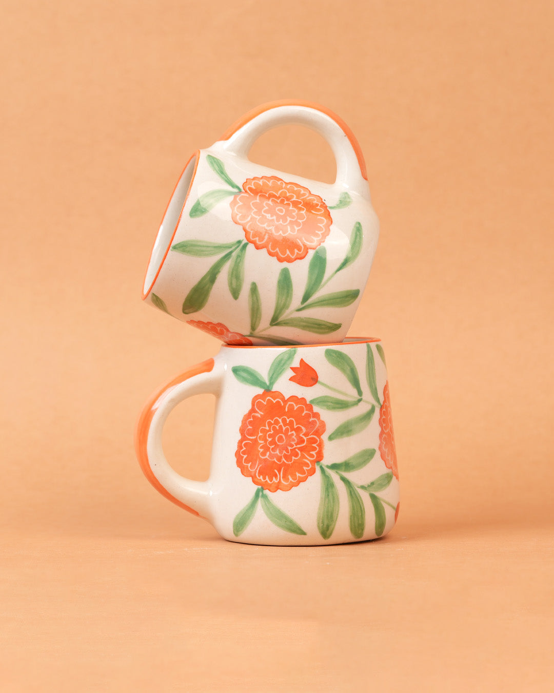 Two floral mugs stacked on a beige background