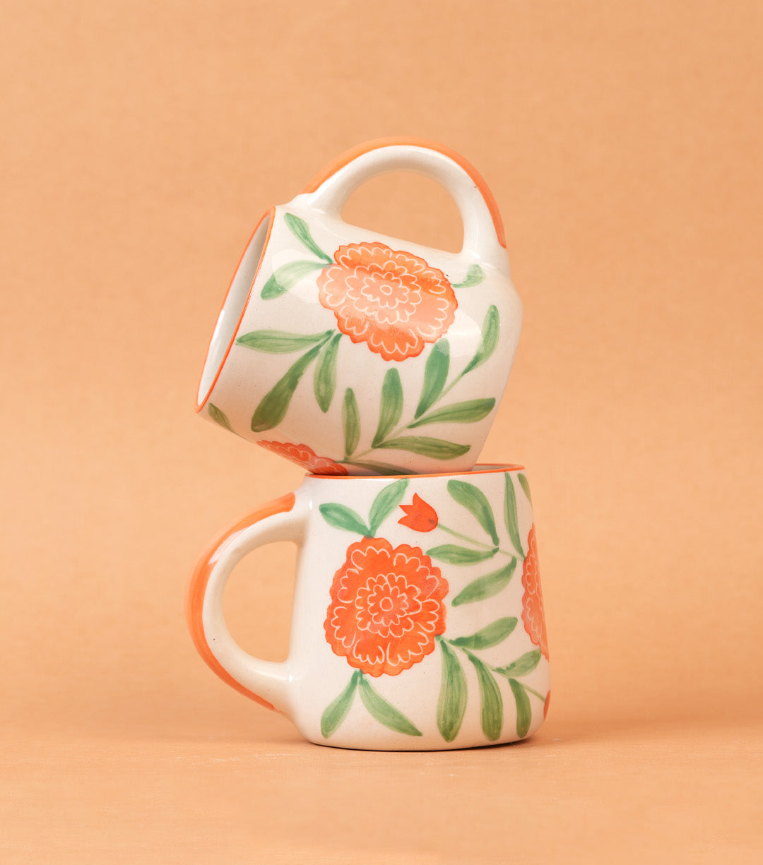 Two floral mugs stacked on a beige background
