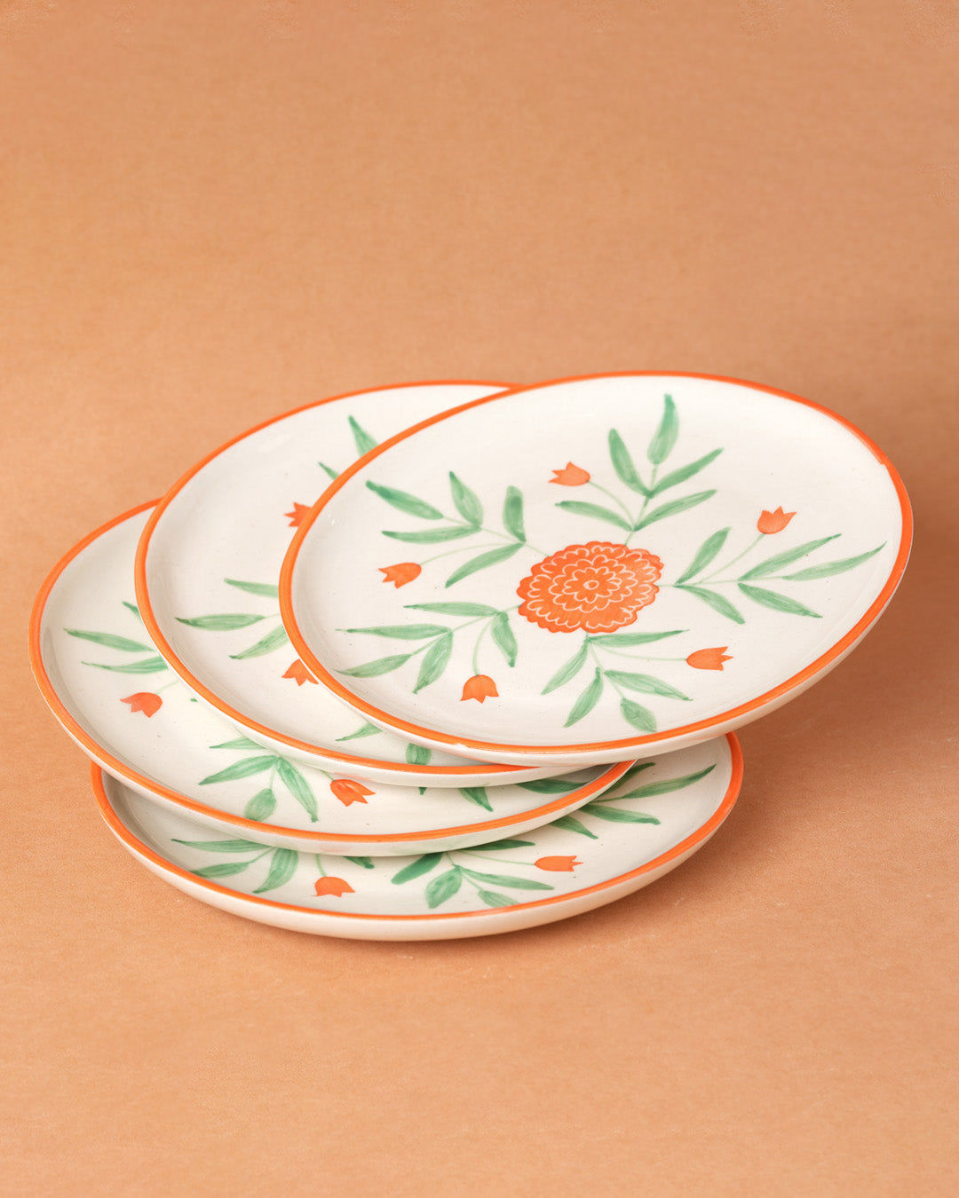 Set of three decorative plates with floral patterns on a brown background