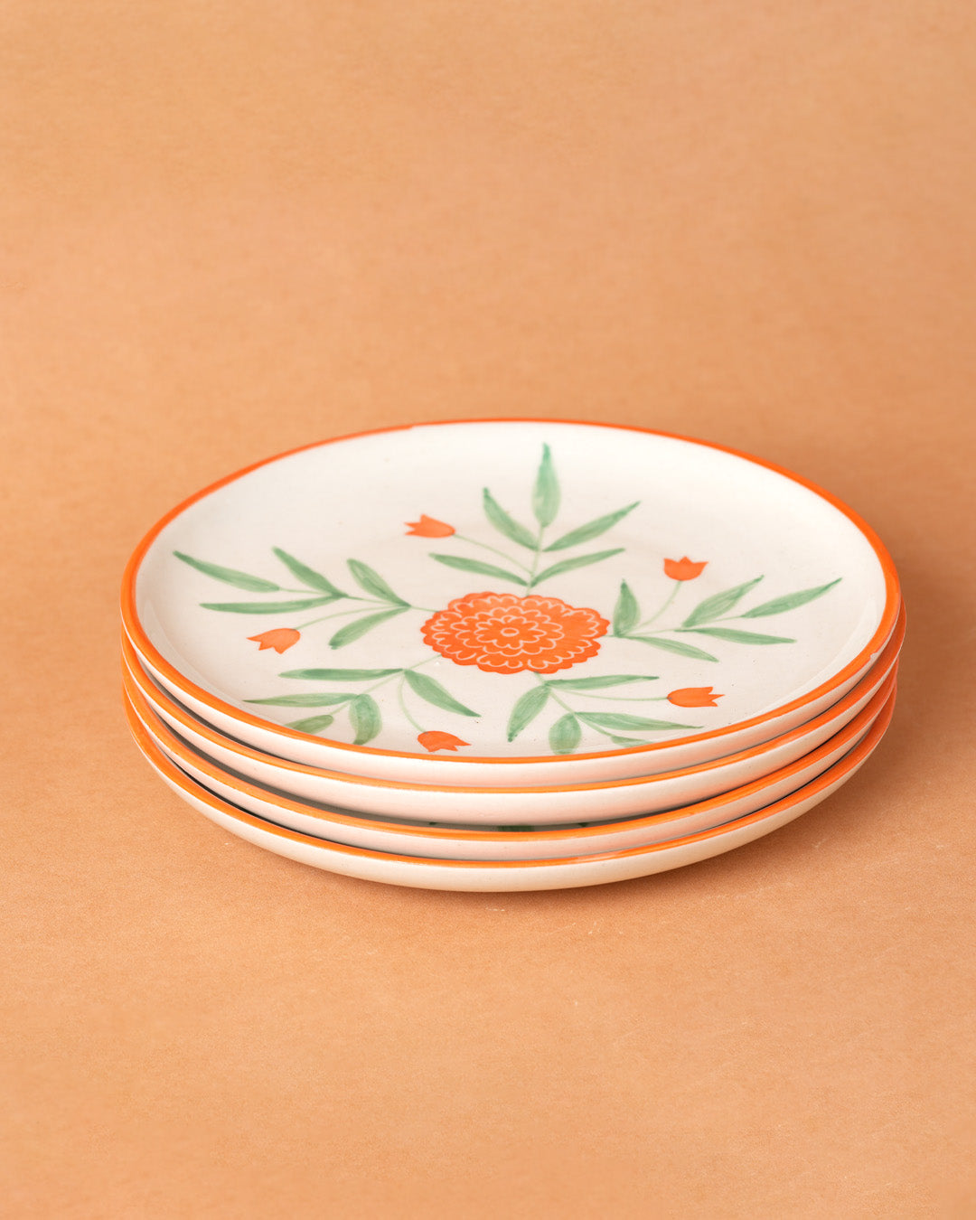 Set of four decorative plates with floral patterns on a beige background