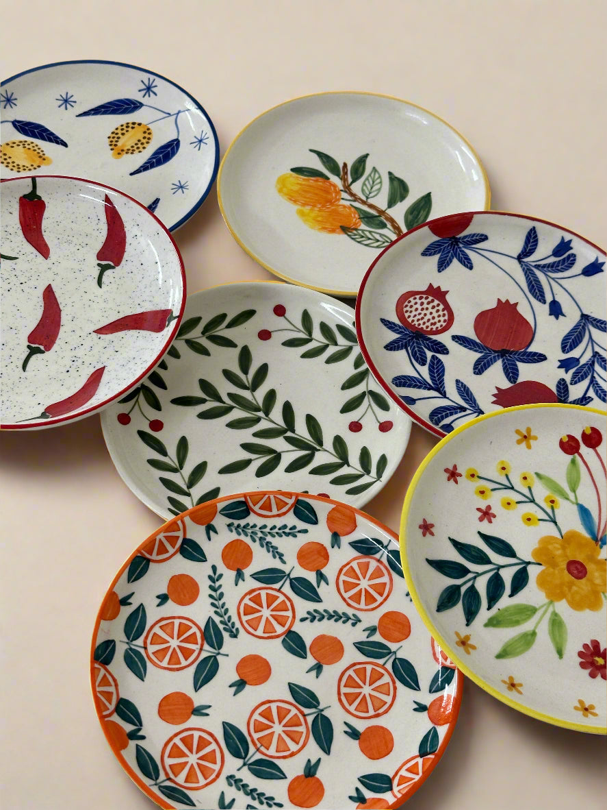 Set of colorful ceramic plates with various patterns on a white surface