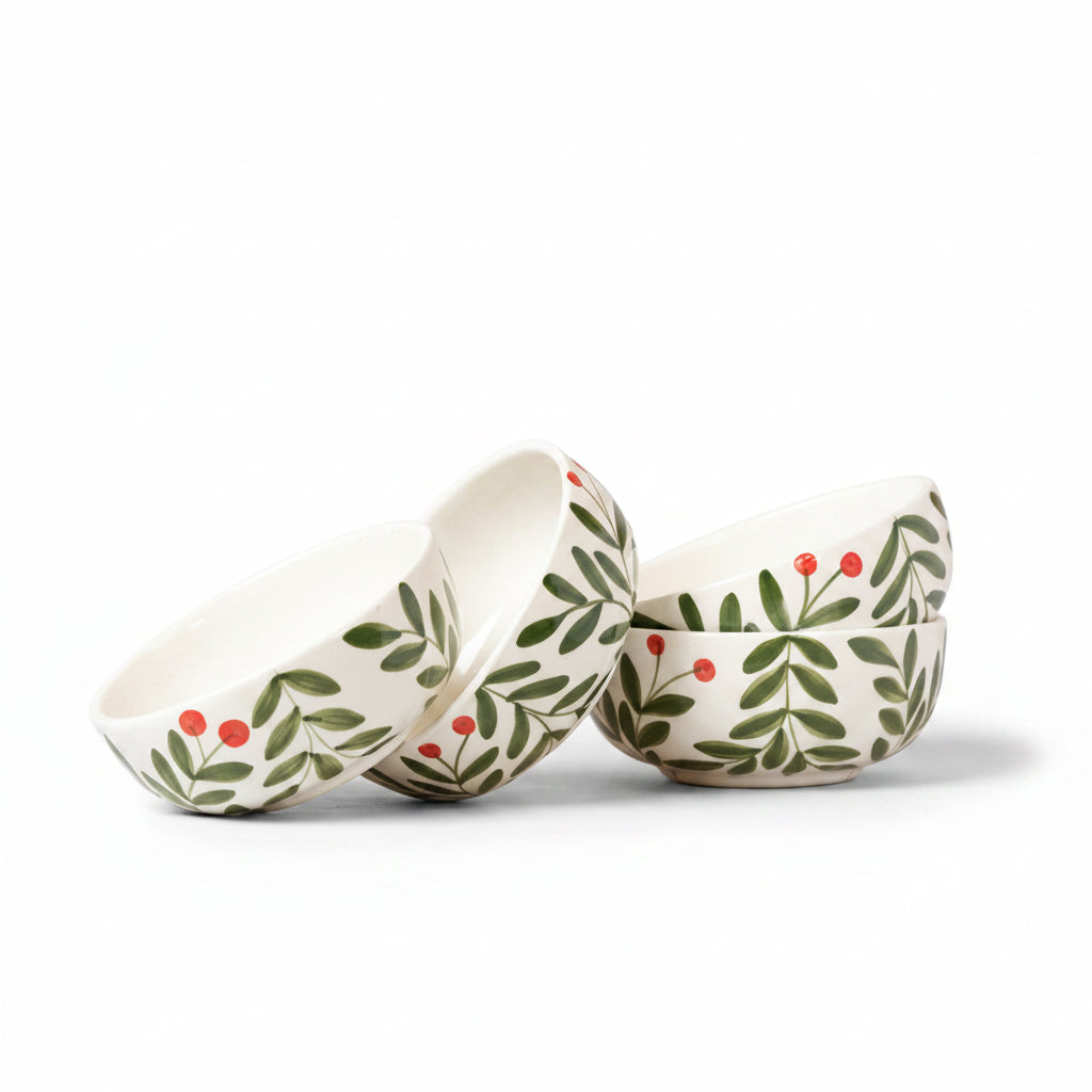 Three ceramic bowls with leaf and berry pattern on a beige background
