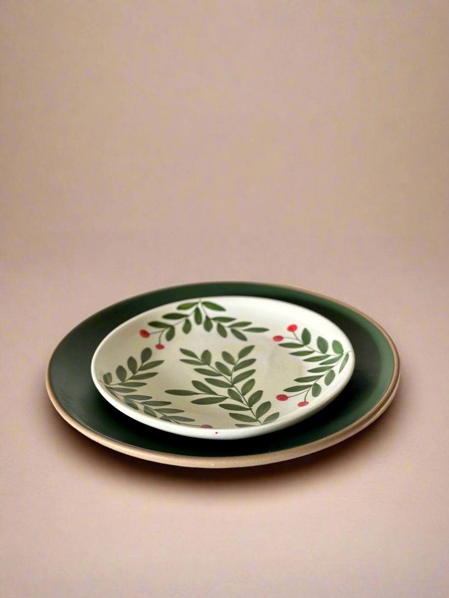 Ceramic plate with green leaf design on a white surface
