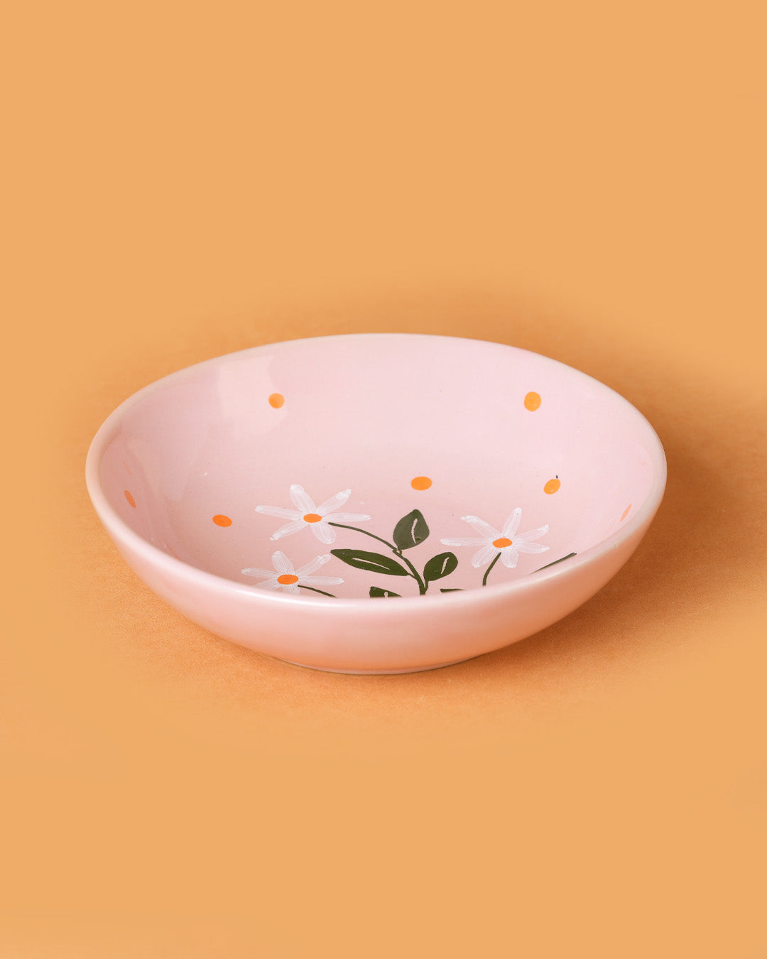Pink ceramic bowl with floral design on a beige background
