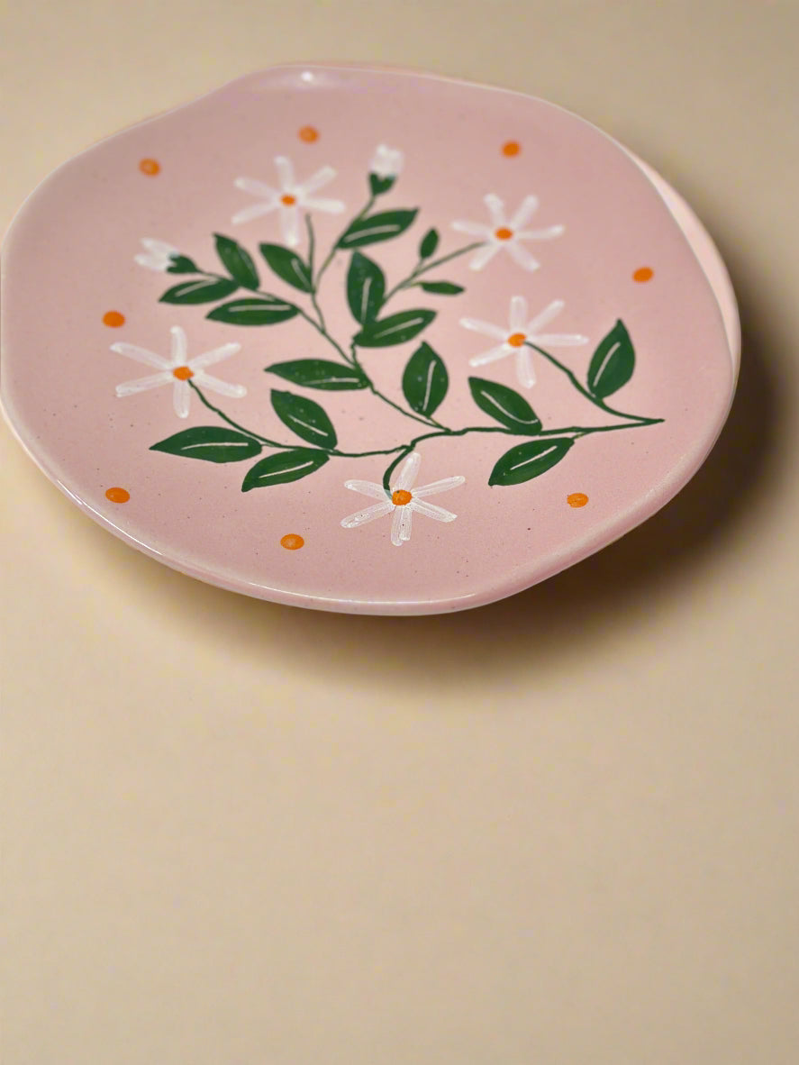 Pink plate with floral design on a beige background