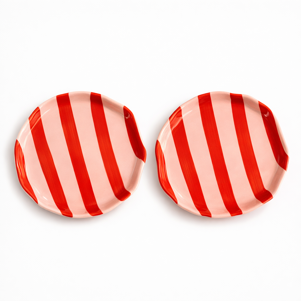 Two round ceramic plates with red and white striped pattern on a white background