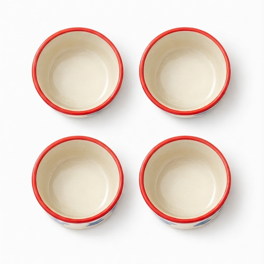 Four ceramic ramekins with red rims on a white background