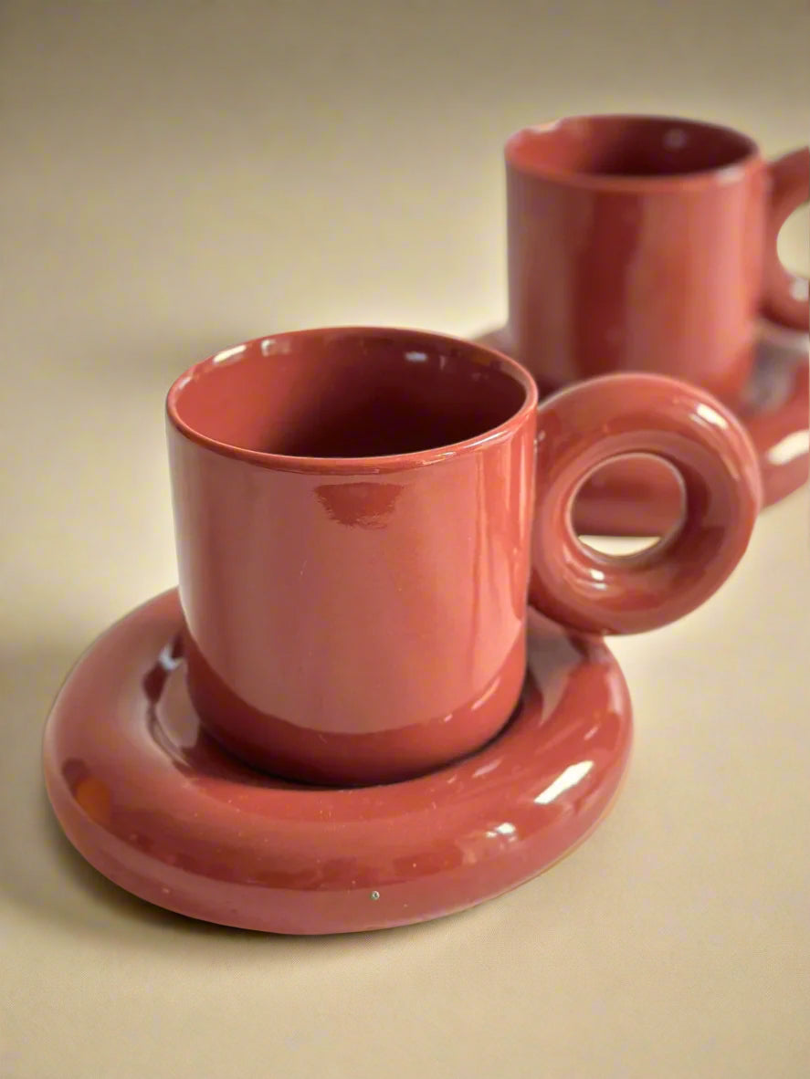 a couple of cups and saucers sitting on a table