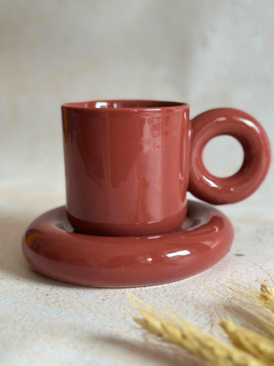 a red coffee cup sitting on top of a saucer