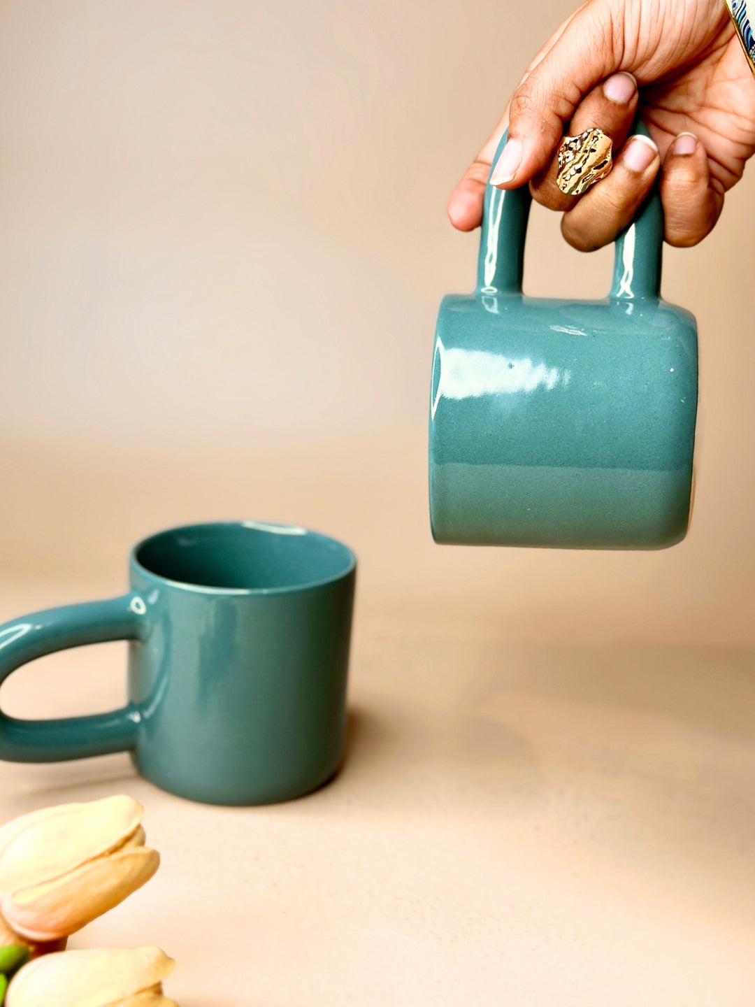 a person pouring a cup of coffee from a teapot