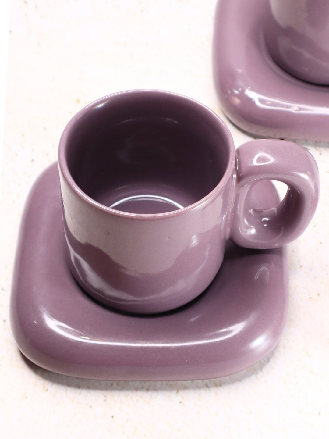 a purple cup and saucer on a white table