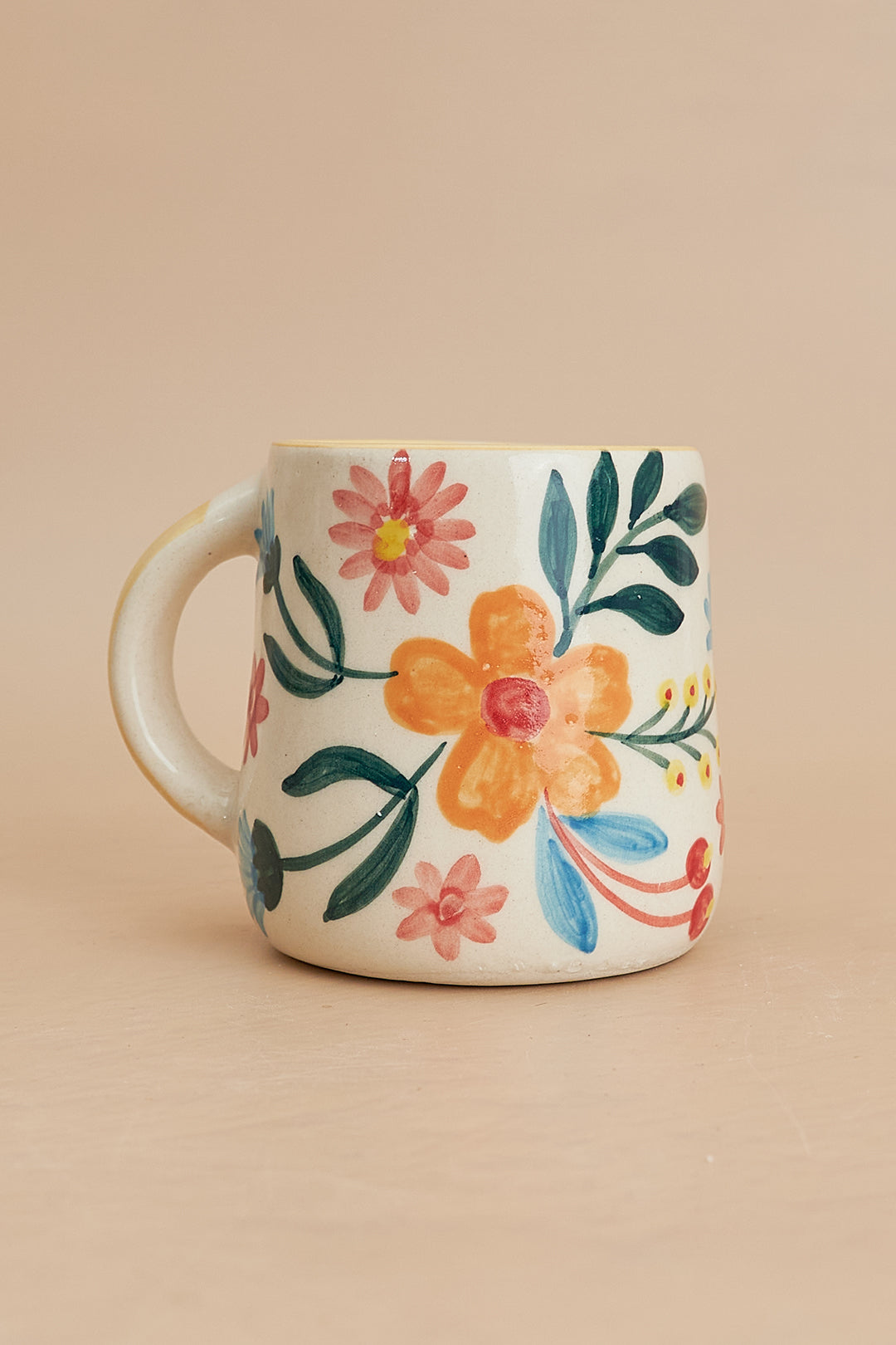 a coffee cup with a flower painted on it