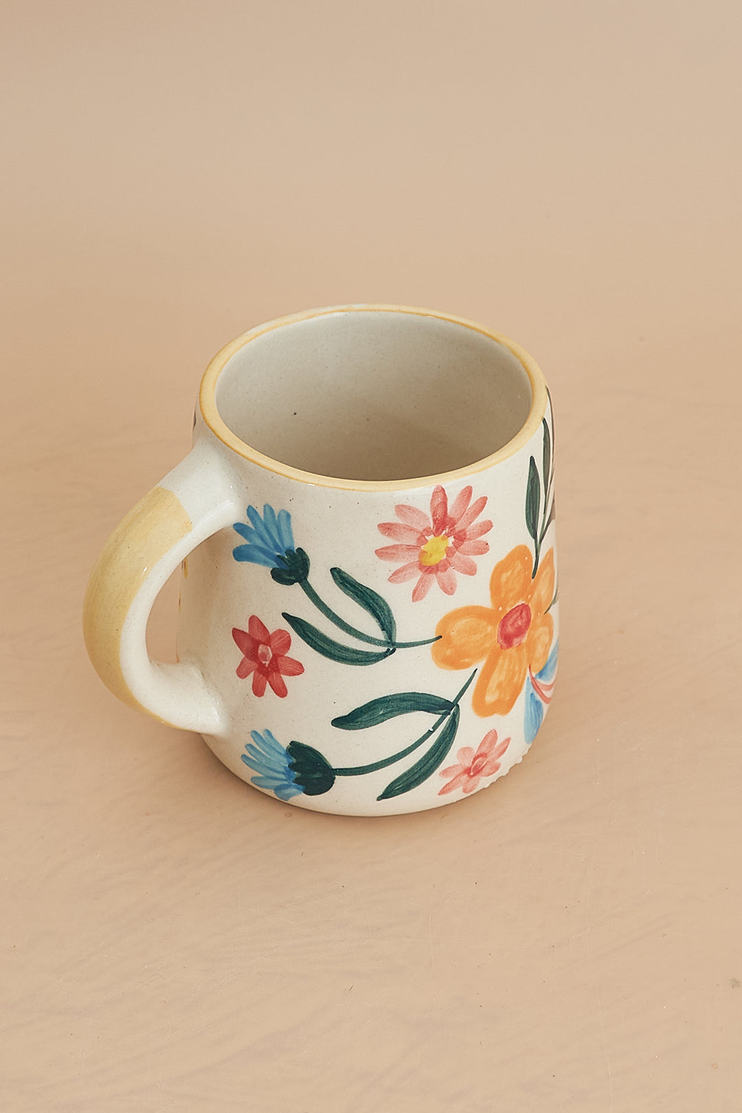 a coffee cup with a handle painted with flowers