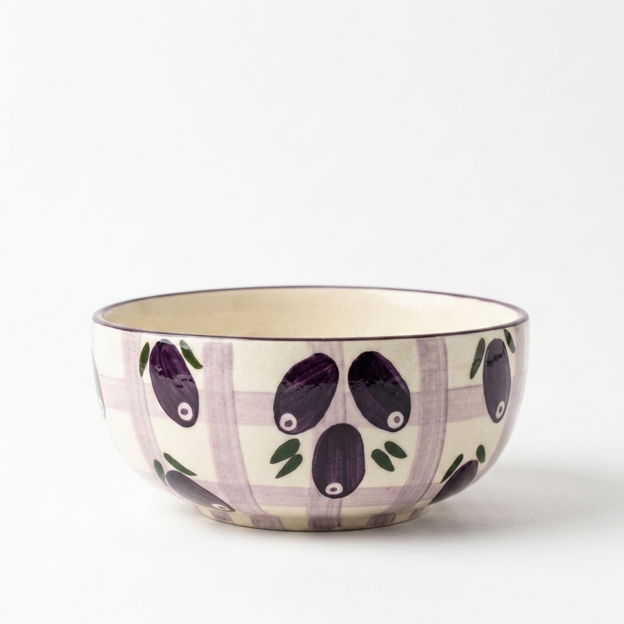 A ceramic bowl featuring a purple and white gingham pattern with hand-painted purple olives and green leaves on the exterior, set against a clean white background.