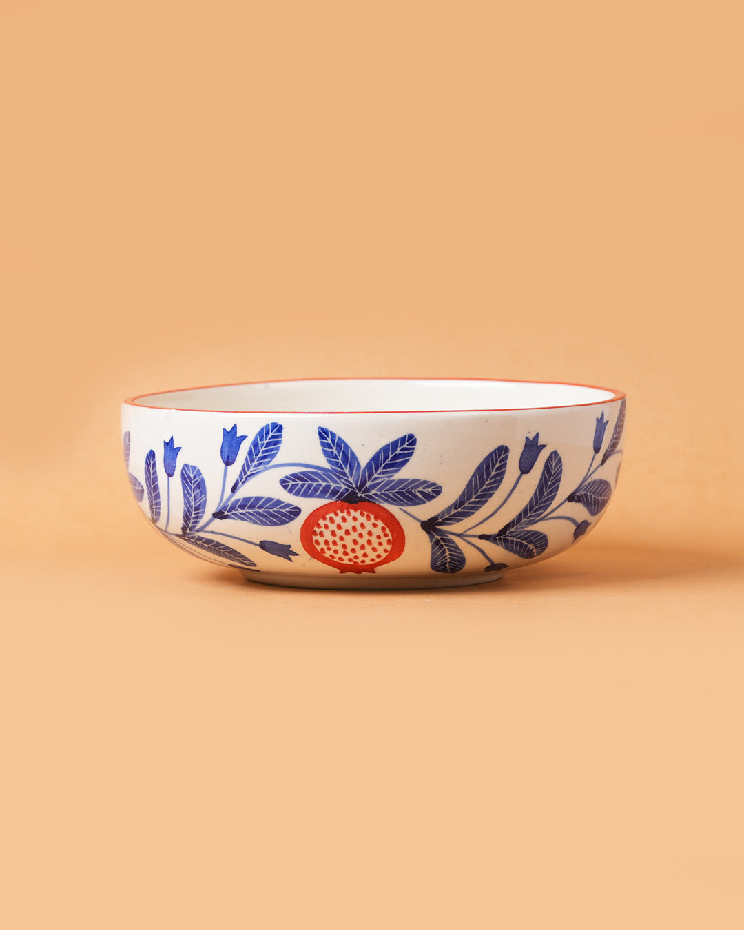 Ceramic bowl with floral and fruit design on a beige background